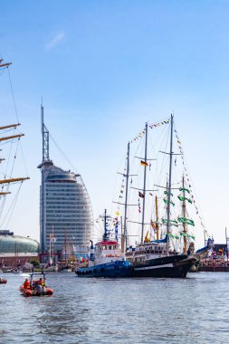 Bir römorkör, Almanya 'nın orta kesimindeki Yeni Liman' da 13 Ağustos 2025 'teki güzel 2025 yelkenli yarışı için güzel bir yelkenliyi iskelesine doğru iter.