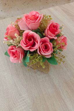 Tahta bir masa arkasına yerleştirilmiş kırmızı gül buketi. Doğa, aşk, sevgililer günü, kopyalama alanı.