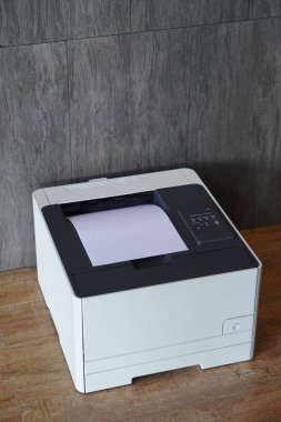 Üst görünüm lazer yazıcısı ahşap bir zeminde dinleniyor, gri kiremit duvar zemin, dekor, teknoloji, moda, iş yeri, kopyalama alanı                              