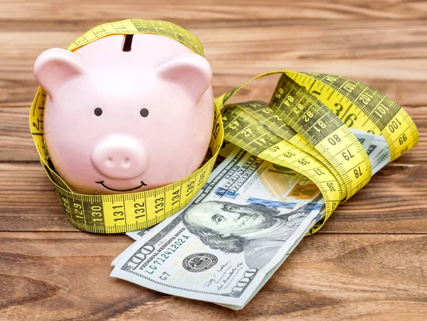 Piggy Bank Com Fita Métrica Dinheiro Fundo Madeira — Fotografia de Stock