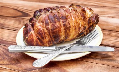 Tabakta tütsülenmiş et, çatal ve bıçak var.. 