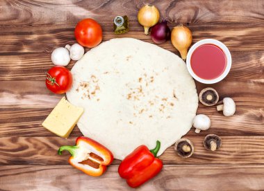 Ahşap arka planda çiğ pizza malzemeli pizza için Hamur. Üst görünüm.