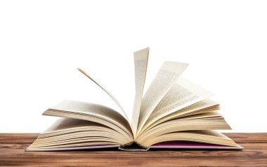 Ahşap masanın üzerinde açık bir kitap. Beyazda izole edilmiş.