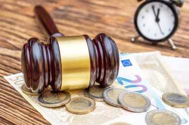 Yargıç tokmağı Euro ve saatle ahşap masada..