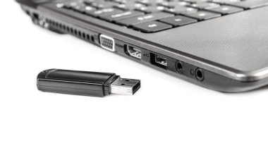 Beyaz arka planda dizüstü bilgisayarı olan USB flash disk.