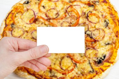 Kadın eli boş bir şekilde masada taze pişmiş pizzayla duruyor..