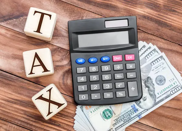 税收概念 计算器 钱和木制立方体与字Tax在桌子上 顶部视图 — 图库照片