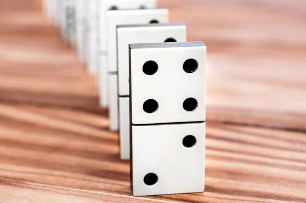 Row of dominoes on the wooden table.