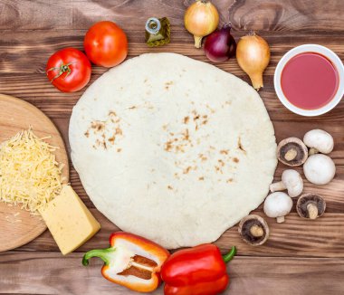 Pizzanın malzemeleri ahşap arka planda. Üst görünüm.