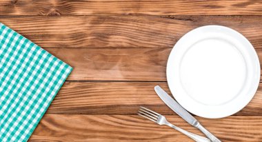 Çatal, bıçak ve mutfak havlusuyla dolu boş tabak. Üst Manzara. Boşluğu kopyala.