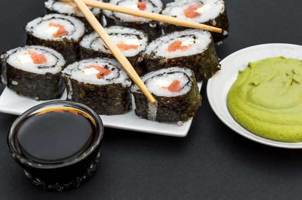 Sushi Bacchette Sul Piatto Con Salsa Soia Wasabi Fondo Nero — Foto Stock