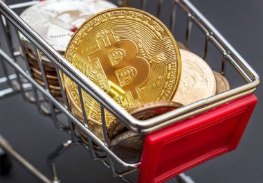 Dekoratif alışveriş arabası ve siyaha basılmış bitcoin paralar. Kapatın. İş ve e-ticaret kavramı.