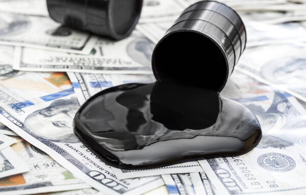 Целый баррель нефти и сырой нефти пролился из барреля на долларовые купюры. 