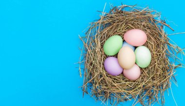 Mavi arka plandaki saman yuvasında Paskalya yumurtaları. Üst Manzara. Uzayı kopyala Paskalya arkaplanı.