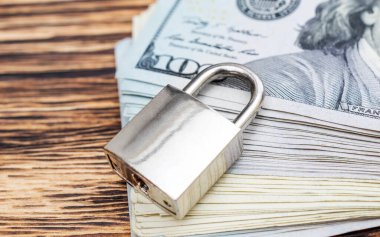 Masasında bir yığın banknot olan asma kilit. Kapat..