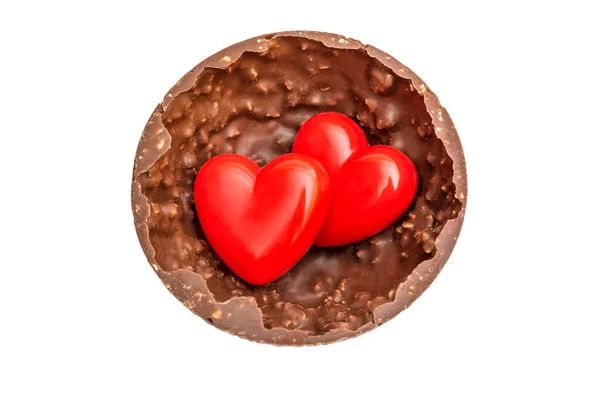 stock image Two red hearts in half of big chocolate candy. Top view. Isolated on white.