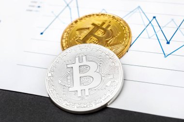 Ticari grafiklerde gümüş ve altın bitcoin madeni paralar. E-ticaret kavramı.