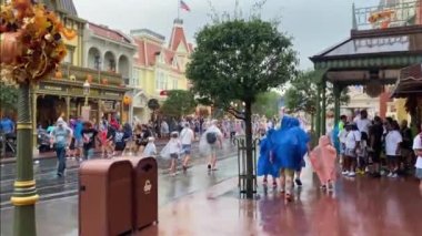 Orlando, Florida. 13 Ekim 2022: İnsanlar yağmur mevsiminde Magic Kingdom Tema Parkı boyunca yürüyorlar