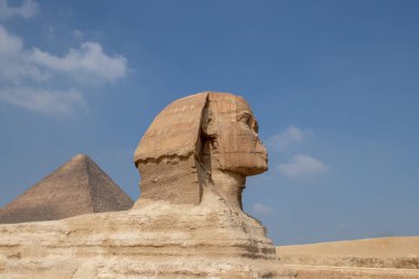 Beautiful profile of the Great Sphinx including pyramids in the background on a clear sunny, blue sky day in Giza, Cairo, Egypt, Africa