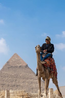 CAIRO, EGYPT - 31 Dec 2022. Old arab traditional an on a camel in front of the great pyramid of giza