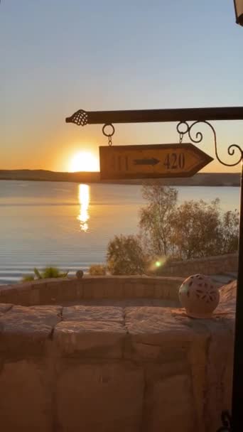 日落时分在湖边酒店张贴箭头标志的垂直视图 — 图库视频影像