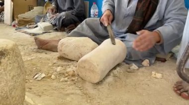 Unrecognizable barefoot artisain african man handmaking alabaster product in Egypt