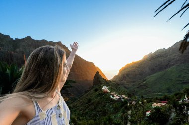 Tenerife, Masca Vadisi 'nde yemyeşil bir yamaçta bir kadın duruyor..