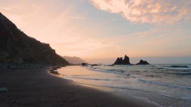 Güneşin Benijo Plajı, Tenerife 'deki sahilin kıyısında batışının huzur verici güzelliğini hissedin..