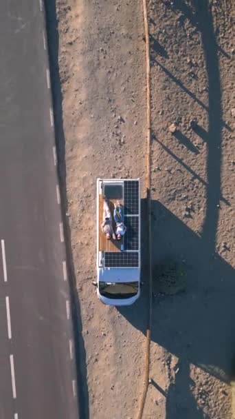 Vista Aérea Dois Jovens Deitados Terraço Trailer Van Área Deserta — Vídeo de Stock