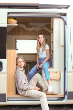 İki genç, lüks bir karavanın girişinde rahat bir gezintinin tadını çıkarır..