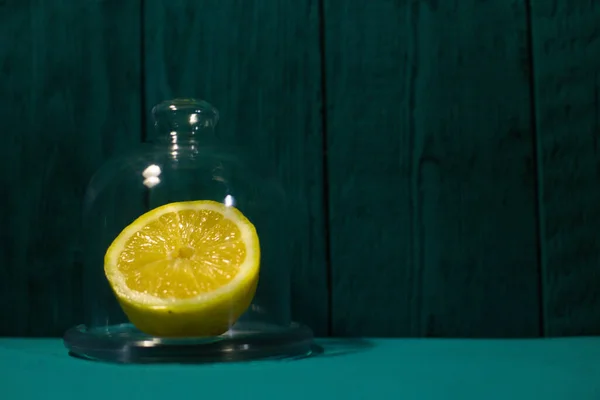 A fresh lemon cut in half in a glass lemonade on a beautiful, dark background