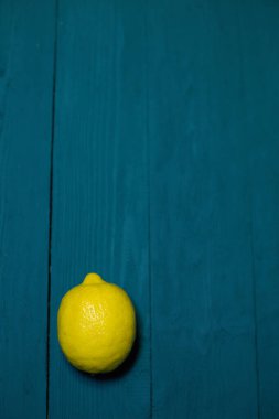 Ahşap desenli mavi bir zemin üzerinde taze limon, yazıtlar için yer