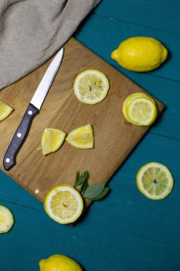 Tahtada dilimlenmiş taze limonlar. Bıçak ve çuval bezi ile.