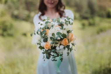 Beyaz elbiseli gelin ve bir buket gül.