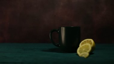 Bardak siyah limonlu sıcak, aromatik çayla dolu.