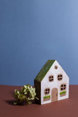 Sade bir arka planda boyalarla boyanmış el yapımı ahşap bir ev.