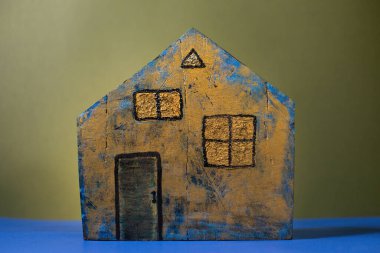 Sade bir arka planda boyalarla boyanmış el yapımı ahşap bir ev.