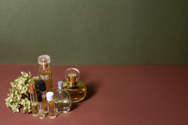 Cam parfüm şişeleri ve arkaplanda ortanca ağaçları.