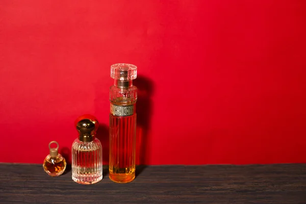 Schöne Glasgefäße Mit Parfüm Auf Rotem Hintergrund — Stockfoto