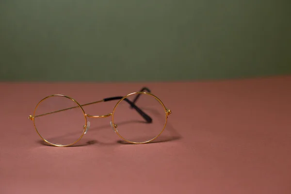 Gold-rimmed glasses on a beautiful background
