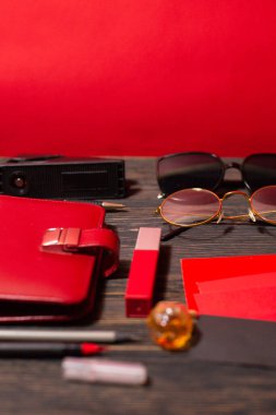 Kırtasiye malzemeleri ve kırmızı arka planda kırmızı renkli kadın aksesuarları
