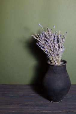 Güzel bir arka planda lavanta çiçekleri olan siyah sürahi.