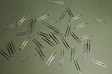 Kağıt raptiyeler düz bir arkaplanda serilmiştir.