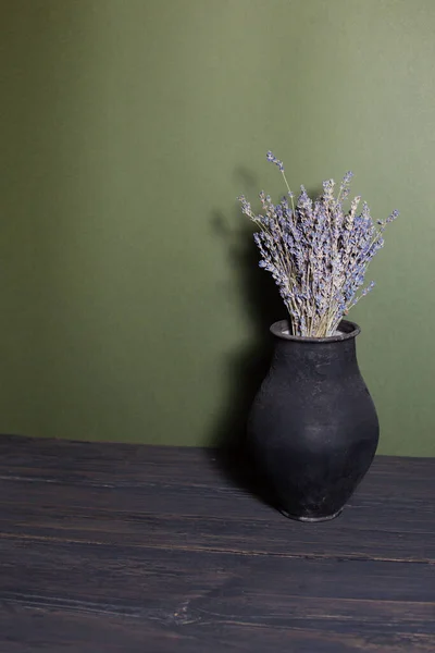 stock image black jug with lavender flowers on a beautiful background