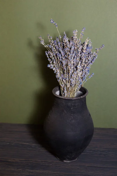 Güzel bir arka planda lavanta çiçekleri olan siyah sürahi.