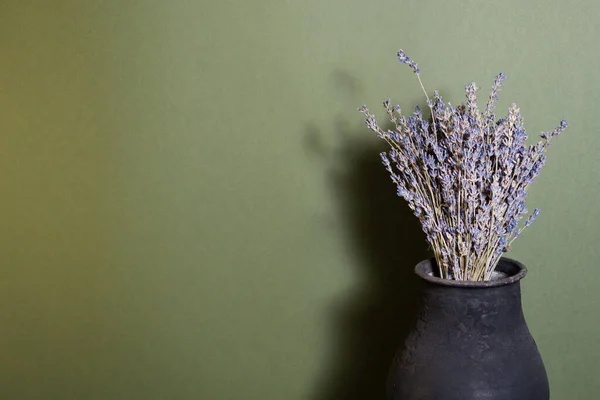 stock image black jug with lavender flowers on a beautiful background