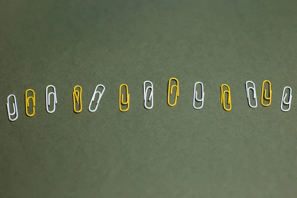 stock image yellow and white paper clips on a plain background