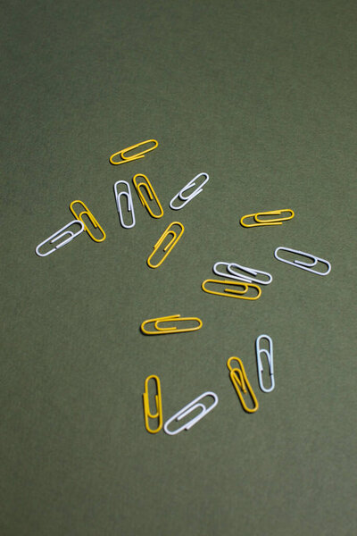 yellow and white paper clips on a plain background