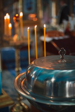 Kilisede bir çocuğun vaftiz töreni, vaftiz sürecinin detayları.