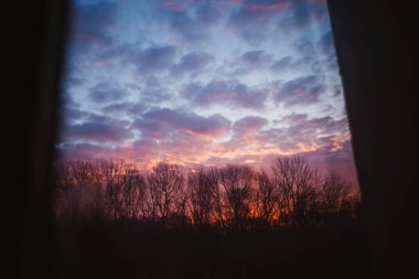 Gün batımında bulutlar, pencereden manzara